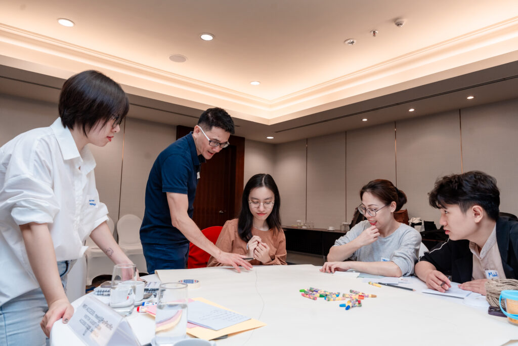 The ECUE team collaborates on a team-building exercise at the Investing in Women workshop, 